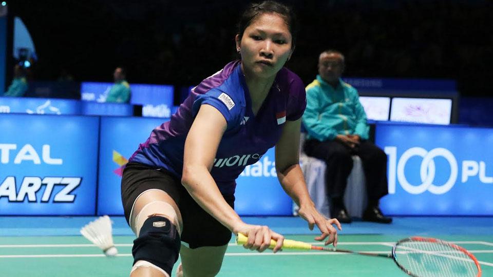 Lindaweni Fanetri berusaha mengambil shuttlecock dari bawah.